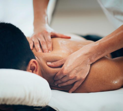 Sports massage on the man upper back